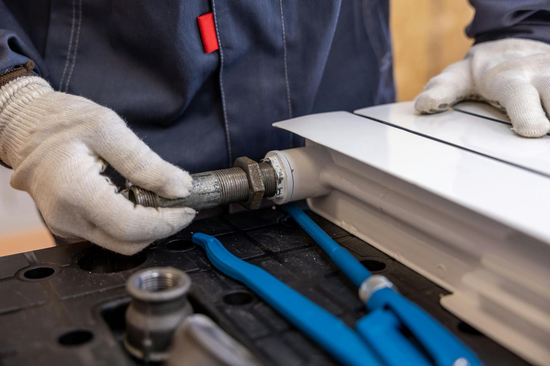 Professional plumber repairing pipe fittings during a slab leak repair in Houston